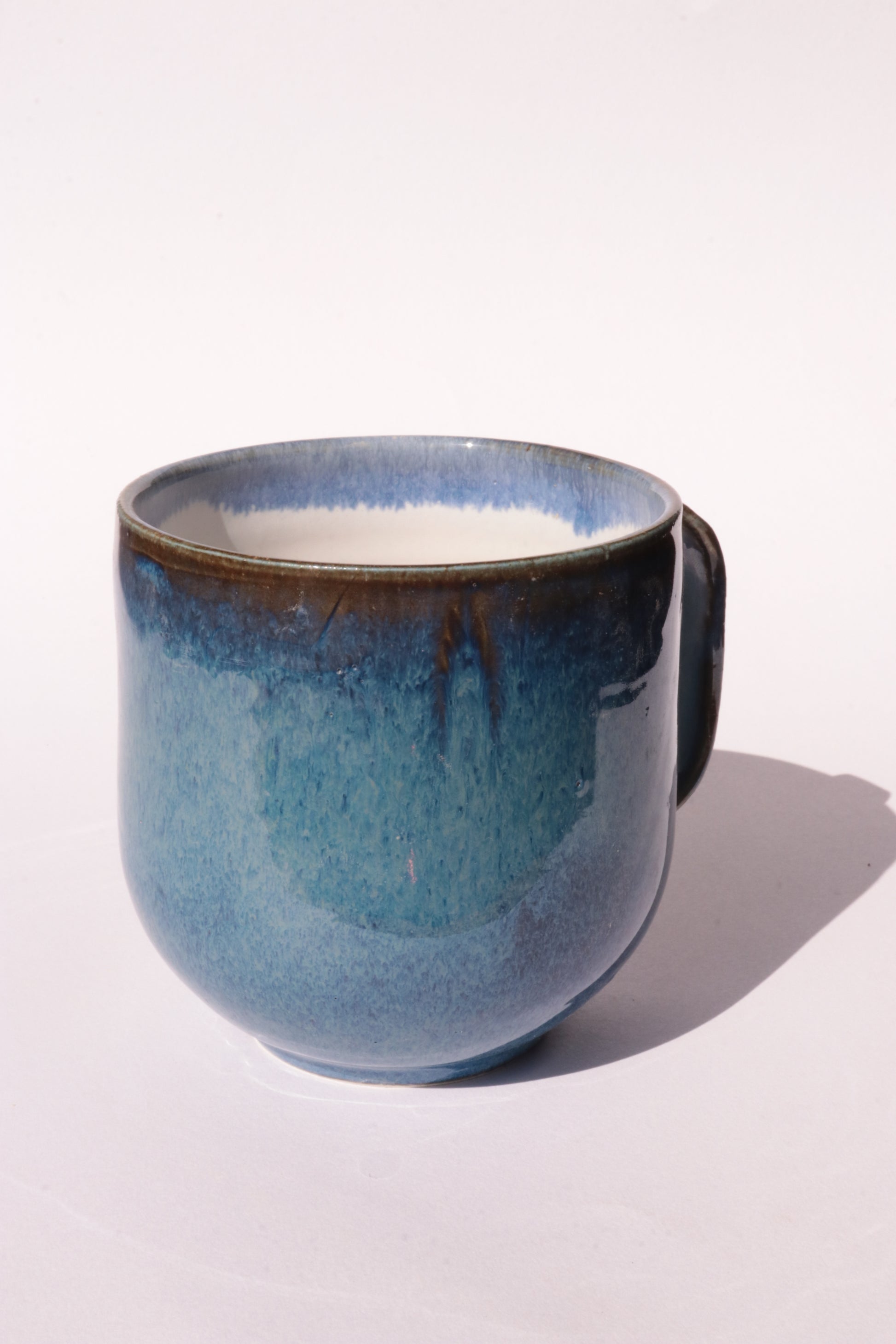 Dark blue mug with subtle engraved design on a white background