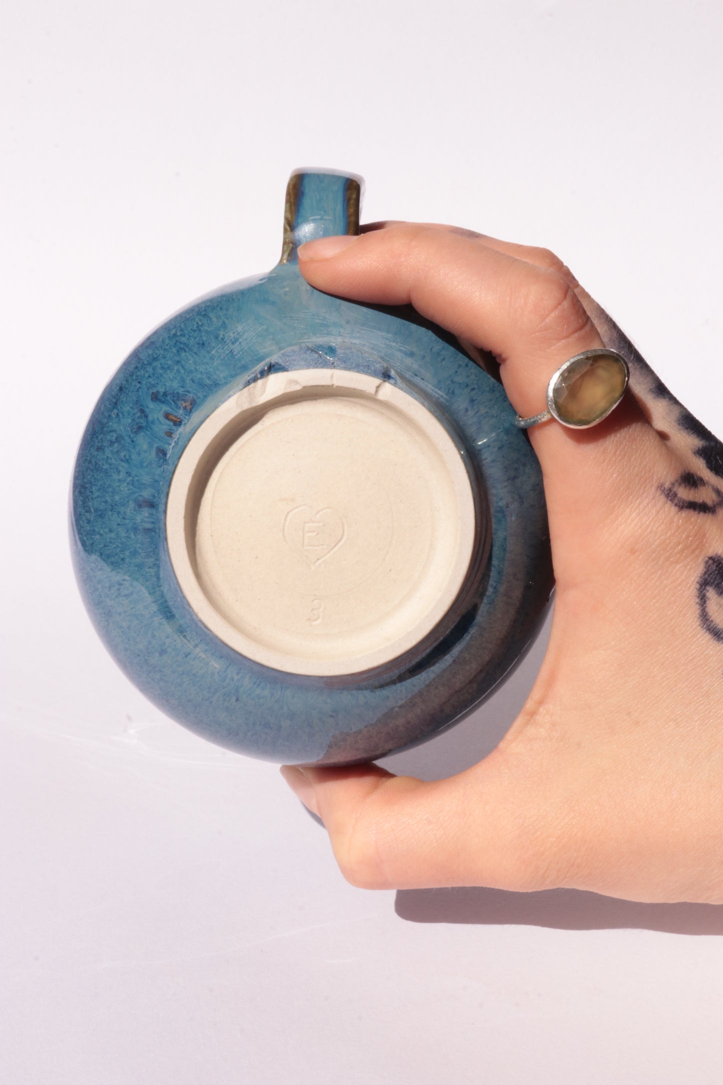 Dark blue mug with subtle engraved design on a white background