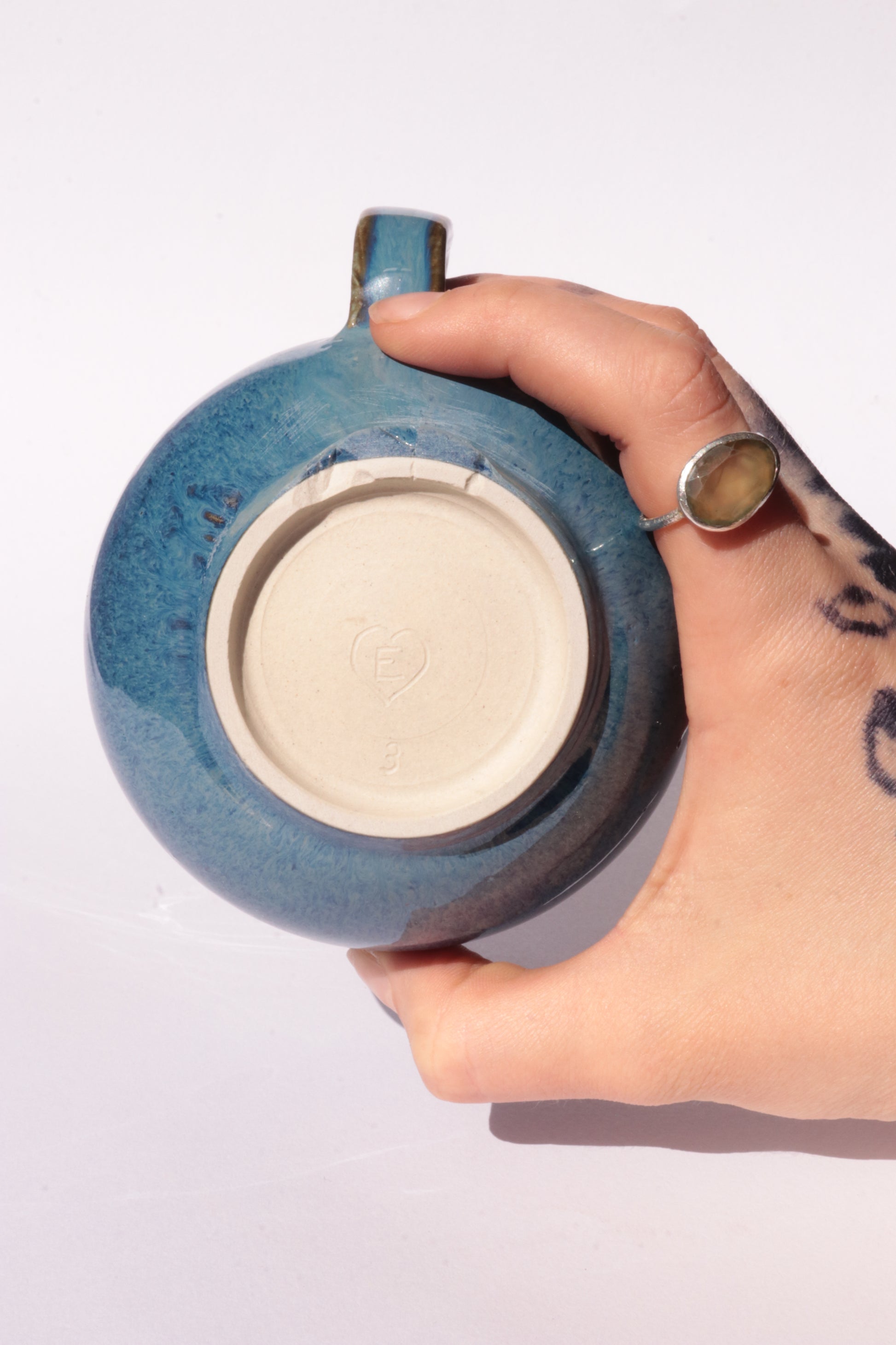 Dark blue mug with subtle engraved design on a white background