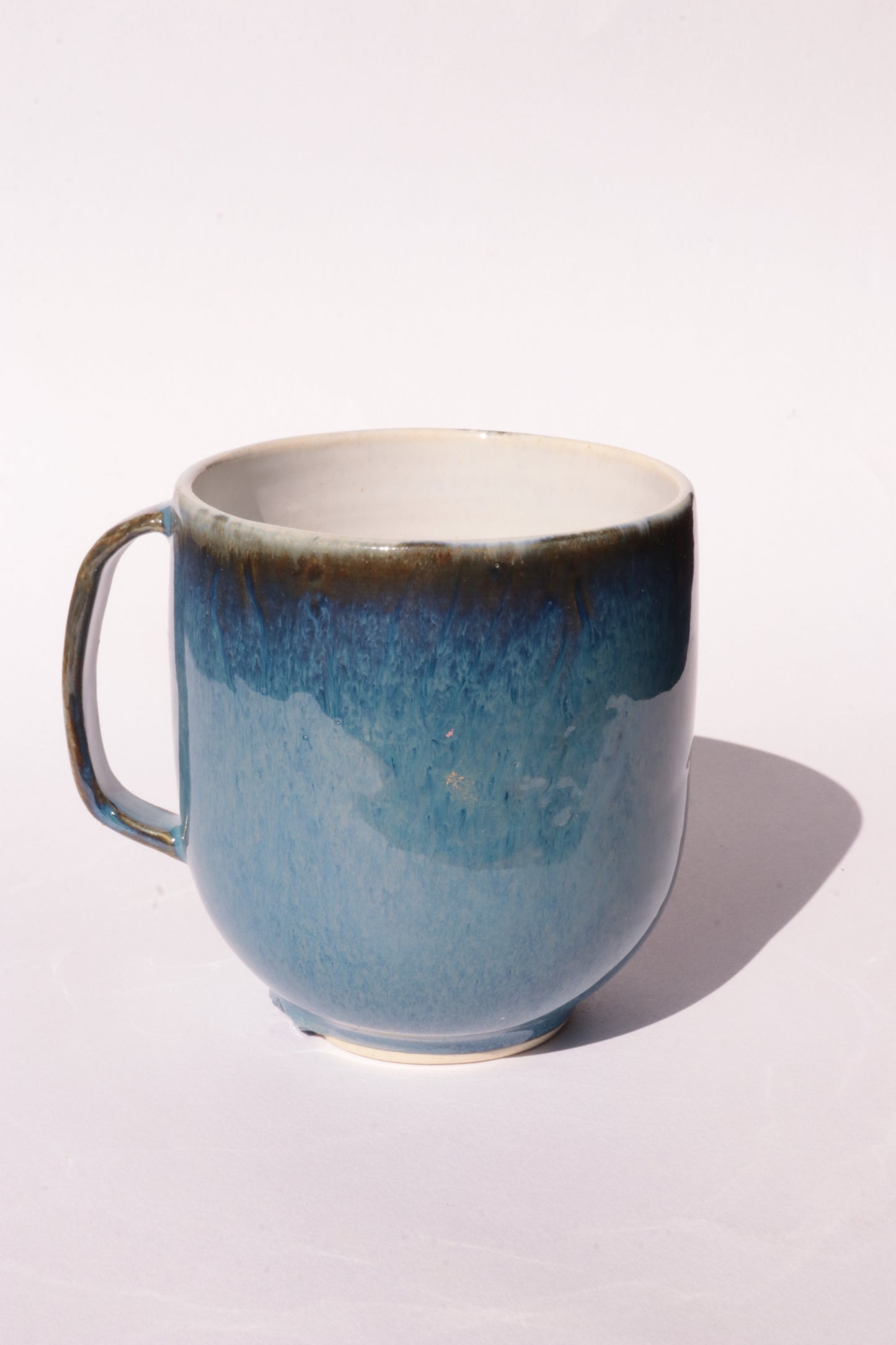 Dark blue mug with subtle engraved design on a white background