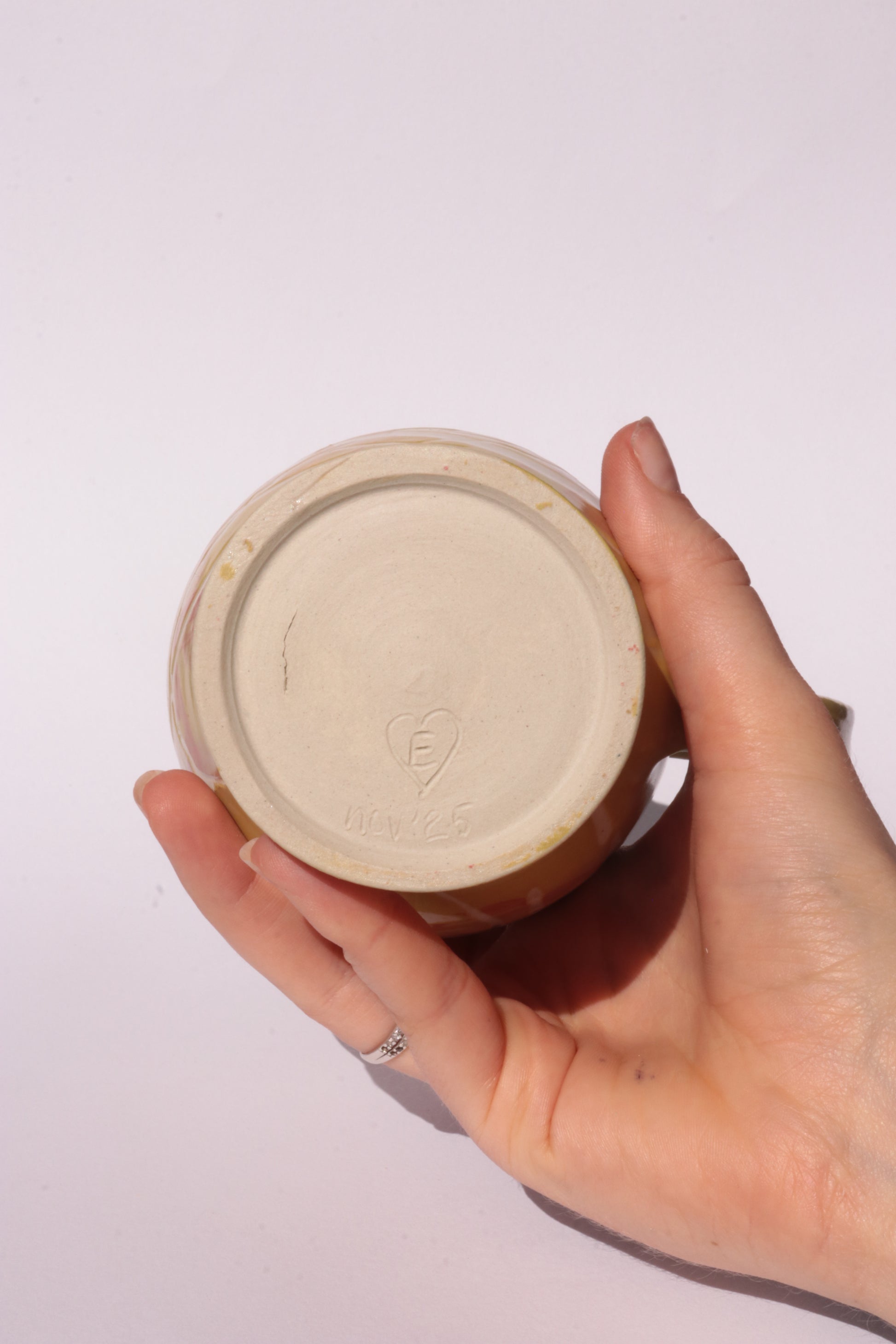 Ceramig jug with colourful engraved design on white background