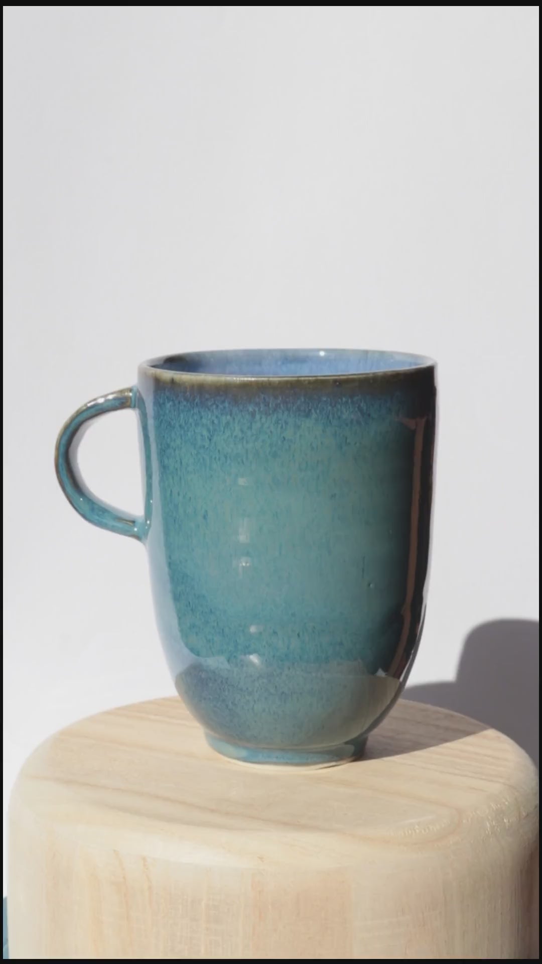 dark blue mug spinning on itself against white background
